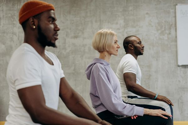 Diverse group of happy people practicing yoga outdoors.