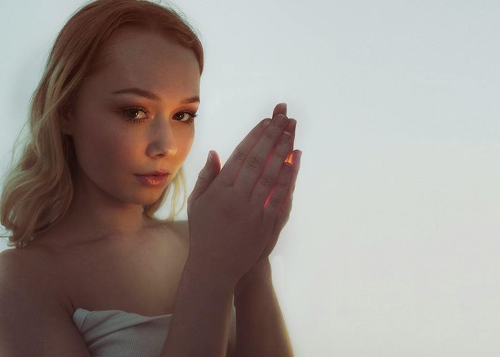 Woman in a calm meditation pose with gentle light.